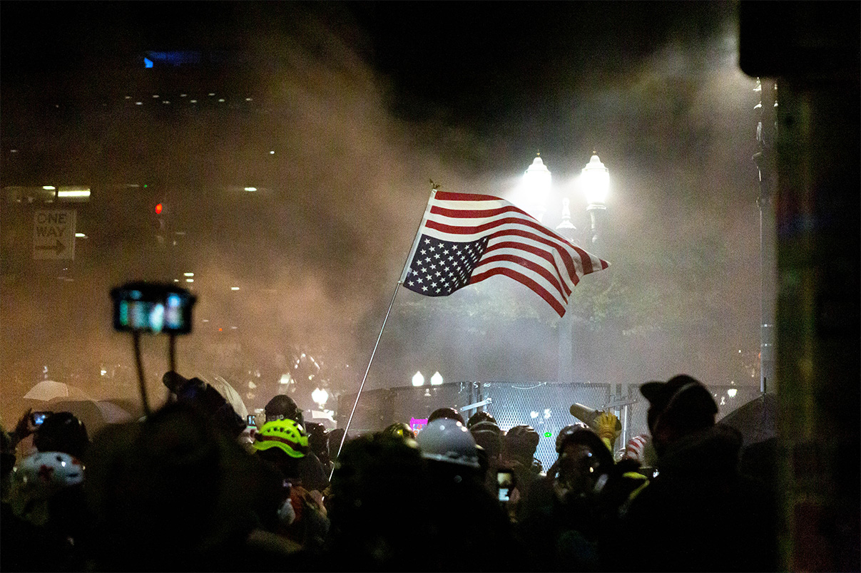 An anti-American protest with a large American flag flying upside down